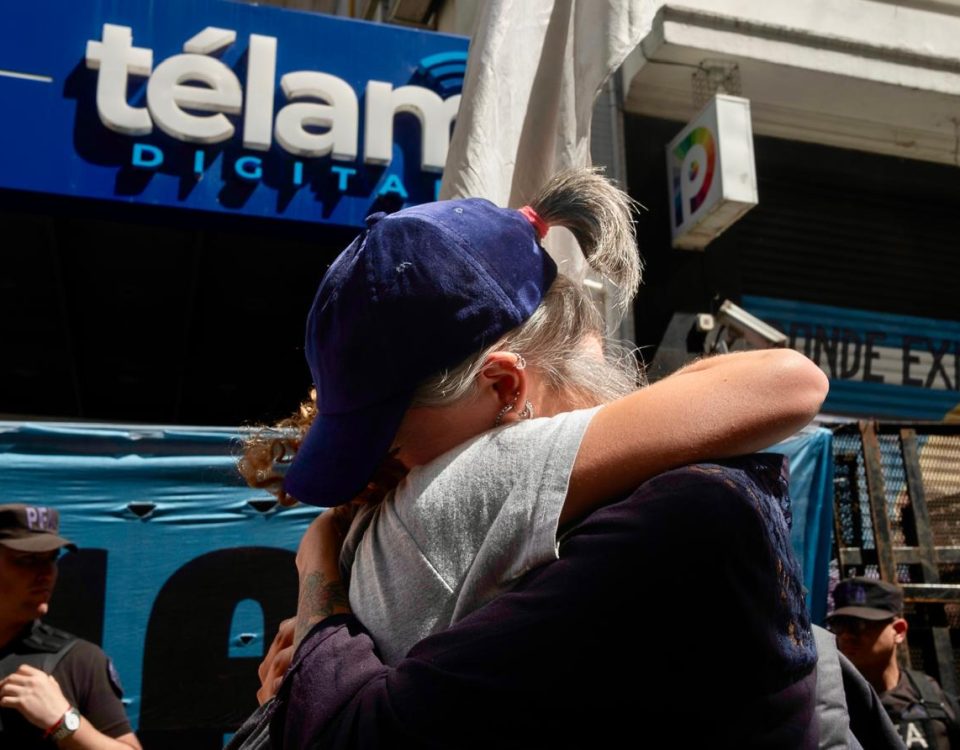 Periodistas se abrazan frente a la pueta de Télam. Foto: Carlos Brigo.
